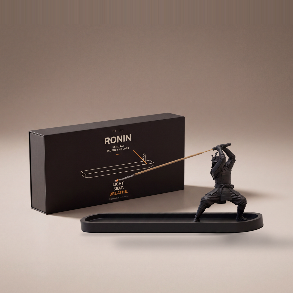 RONIN samurai incense holder by Dellulu — matte black 3D-printed figure holding a burning incense stick over a 250 mm ash dish, shown beside its box